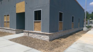Corner showing stone base and concrete sidewalk.